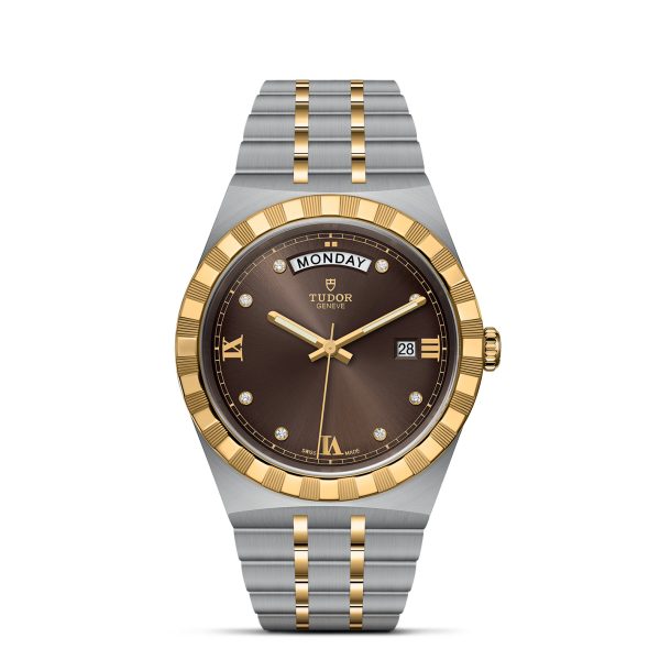 A luxury TUDOR Royal wristwatch with a two-tone gold and stainless steel bracelet. The watch features a round brown dial with gold hour markers, a day window at the 12 o'clock position, and a date window at the 3 o'clock position.