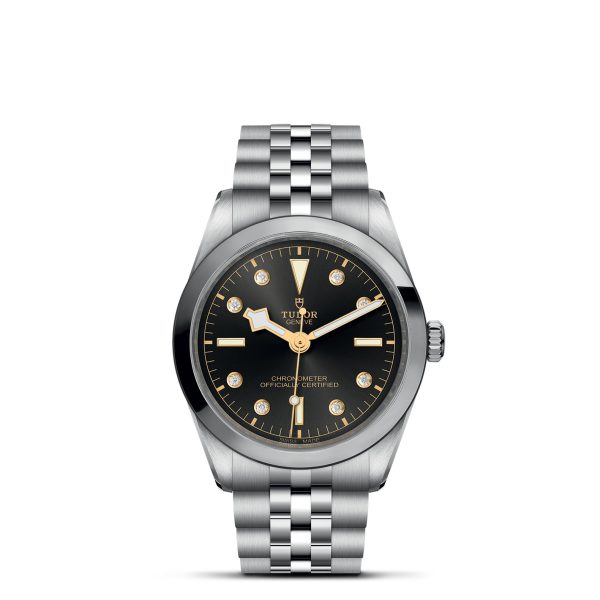 The TUDOR Black Bay 36 is a luxury wristwatch featuring a black dial with diamond hour markers, silver hands, and a date display at 3 o'clock. It boasts a silver stainless steel bracelet and is labeled "Tudor" with "Chronometer Officially Certified" on the face.