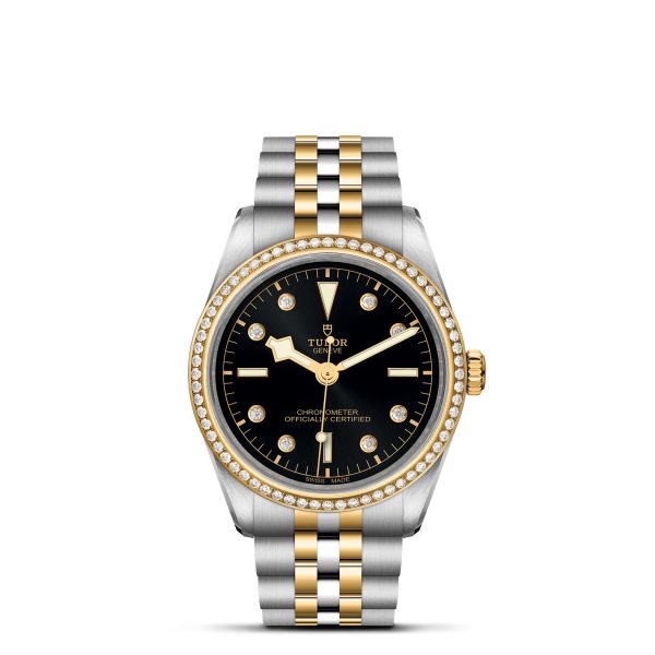 The TUDOR Black Bay 36 S&G is a luxury wristwatch boasting a black dial with diamond hour markers, gold hands, and a date window. It features a stainless steel and gold bracelet, complemented by a bezel adorned with diamonds. The brand name "TUDOR" is prominently displayed on the face.