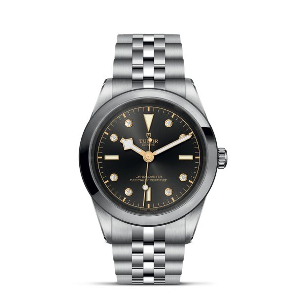 The TUDOR Black Bay 41 is a luxury wristwatch featuring a round black dial adorned with gold-tone hour markers, hands, and minute markers around the outer rim. The watch face includes the Tudor logo and the words "Chronometer Officially Certified," all complemented by a metal bracelet.