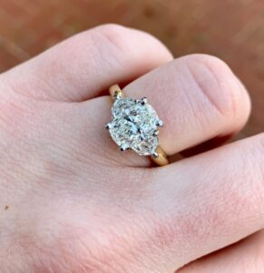 Cushion cut three-stone engagement ring