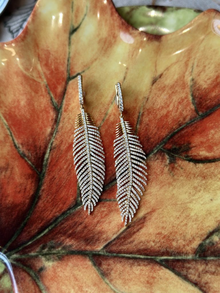 Diamond feather earrings on an autumn leaf plate
