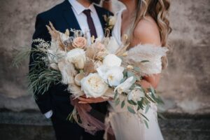 Cropped shot of a bride and groom with a large bouquet in the foreground.