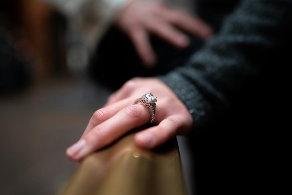 Close-up of a woman’s hand wearing a diamond engagement ring