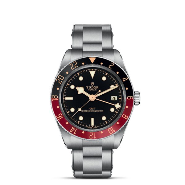 The TUDOR Black Bay 58 GMT wristwatch is displayed with a stainless steel bracelet. The watch features a black dial with luminous hour markers and hands, a date window at the 3 o'clock position, and a black and red bezel with 24-hour markings. The Tudor logo is visible below the 12 o'clock position.