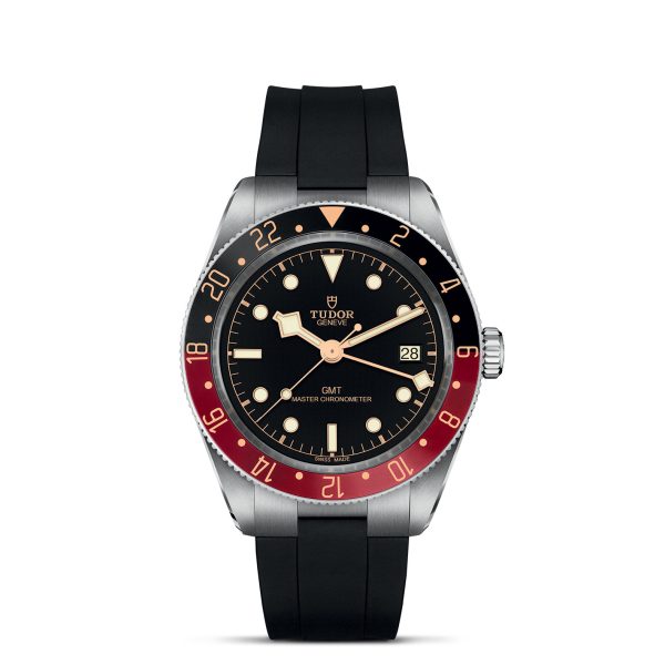 A TUDOR Black Bay 58 GMT watch crafted from stainless steel, featuring a black dial, a red and blue bezel, and a black rubber strap. The watch face includes dot and bar hour markers, a date window at 3 o'clock, and two additional time zone hands. The brand name and logo are prominently displayed just below 12 o'clock.