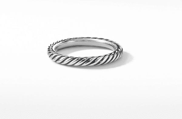 A close-up of the 3MM CABLED STACK RING set against a plain white background. The ring showcases a twisted rope-like design, giving it a textured and elegant appearance. The ring is positioned upright, highlighting its detailed craftsmanship.