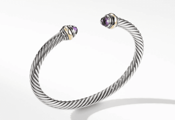 The 5MM COLOR CLASSIC BRACELET AM is a silver bracelet with a twisted cable design, highlighted by gold accents and capped with two faceted purple gemstones at each end, displayed on a white background.