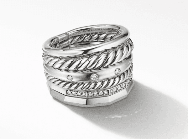 The 16MM STAX WIDE RING features a thick band adorned with multiple intertwined rope patterns and embedded diamond detailing. Its intricate design casts a soft shadow against a white background.