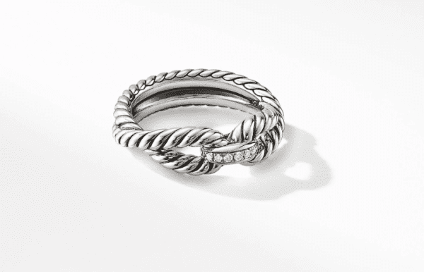 The 8MM CABLE LOOP RING, featuring a silver twisted rope design with a small segment adorned with tiny diamonds, is displayed on a white surface, casting a slight shadow.