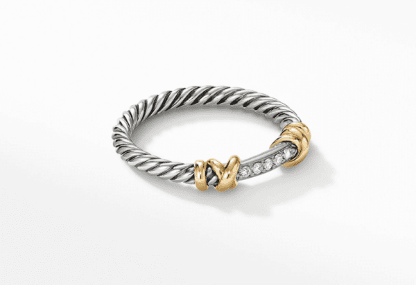 The PETITE HELENA WRAP RING boasts a twisted silver band that highlights a central section embellished with small, white crystals. The ends of this crystal-studded section are capped with detailed gold accents, creating a striking contrast against the silver. The ring is displayed elegantly on a simple white background.