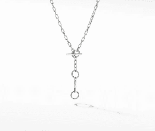 Introducing the MADISON 3 RING CHAIN: a silver chain necklace featuring an elongated link design and a central toggle clasp. Distinctive for its minimalist and modern aesthetic, the necklace boasts two additional circular links that dangle gracefully from the clasp, casting a shadow on a white background.