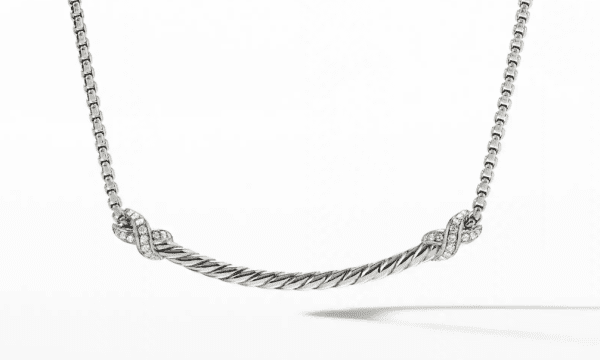 The PETITE X BAR NECKLACE is a silver twisted rope necklace featuring a delicate, curved bar at the center, adorned with small sparkling stones at the ends. The necklace is showcased against a plain white background.