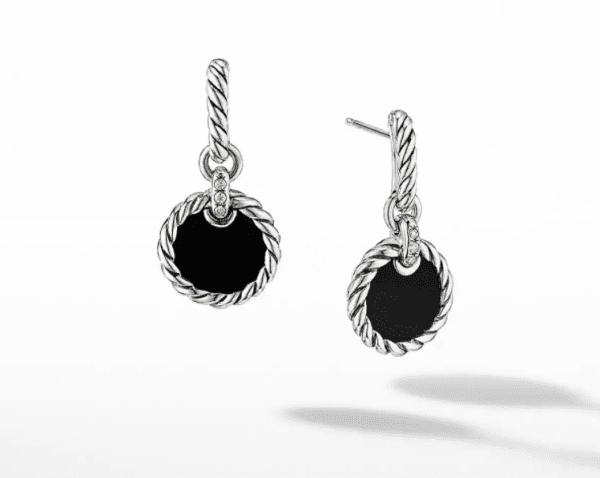 The ELEMENTS DROP EARRINGS are a pair of elegant earrings featuring circular black stones encased in twisted silver rims. The earrings also include a small set of three stones affixed to the hanging loop, which is designed with a matching twisted silver pattern.