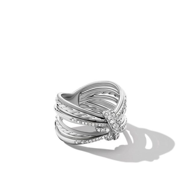 The ANGELIKA FOUR POINTS RING is a multi-band silver ring with a crisscross design, featuring sparkling diamonds on some of the bands. The ring casts a soft shadow on a white background.