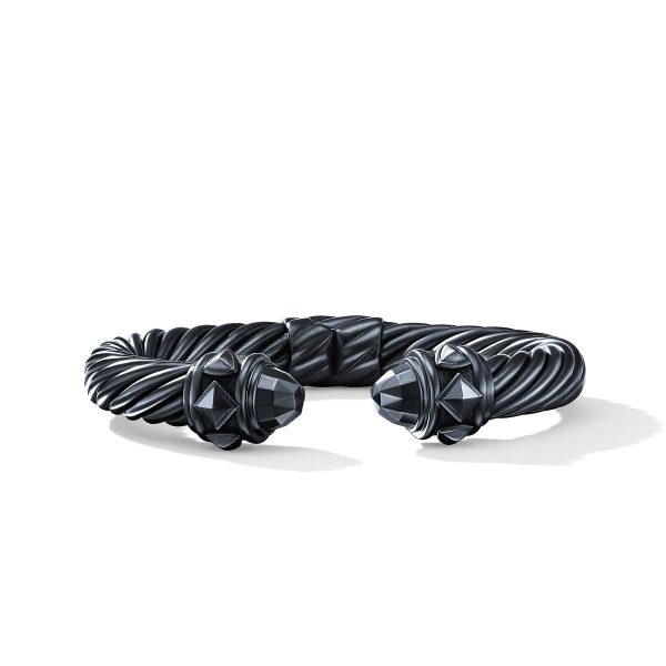 The 9MM RENAISSANCE CABLE is a polished silver bracelet with a twisted rope design, embellished with faceted black gemstone accents at the open ends. This elegant piece casts a soft shadow on a plain white background.