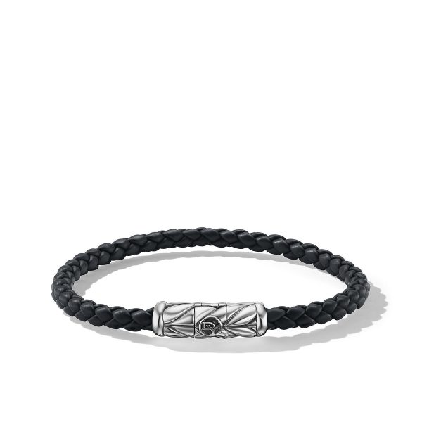 Product Description: The 5.5MM RBR CHEV CLASP BRAC is a refined, black braided leather bracelet adorned with a silver cylindrical clasp showcasing intricate engraved patterns. The clasp is prominently positioned, adding an elegant and sophisticated touch to the minimalist design of the bracelet.