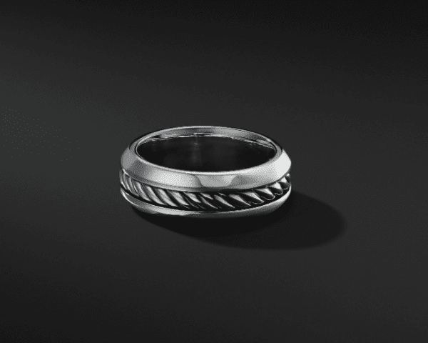 The 8MM CLASSC INSET BAND features a polished silver finish with a recessed twisted rope design in the center, set against a black background. The ring boasts a thick band, maintaining an elegant and modern aesthetic.