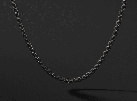 A sleek 2.7MM Mens Box Chain hangs against a dark, speckled background, creating a minimalistic and elegant visual contrast.