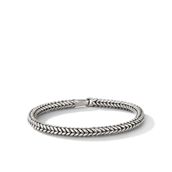 The CHEVRON BEAD BRACELET is displayed on a plain white background. The bracelet features a sleek, woven chain design with intricate detailing, forming a continuous loop. The clasp is subtly integrated into the design, enhancing the bracelet's elegant and seamless appearance.