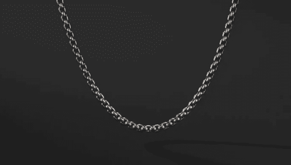 The 2.7MM MENS BOX CHAIN is displayed against a dark background, showcasing its intricate link design. The lighting highlights the polished silver, casting subtle shadows beneath it.