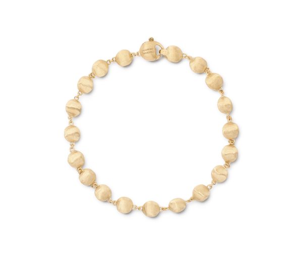 The Marco Bicego Africa Bead Bracelet is an elegant gold bracelet adorned with a series of round, textured beads seamlessly linked together. It boasts a subtle shine and features a minimalist clasp for secure wear.