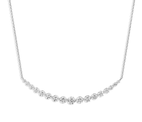 The Bromberg's Signature Collection Diamond Curve Necklace is a delicate silver piece featuring a series of round-cut diamonds set closely together, forming a sparkling strand that extends halfway around the neck. The rest of the necklace is made of a thin silver chain, creating an elegant and symmetrical design.