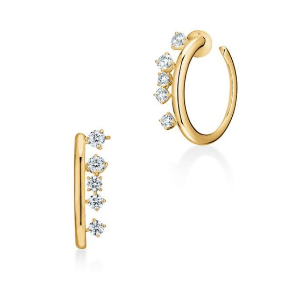 The Hearts on Fire Barre Floating Diamond Hoop Earrings - Small feature five evenly spaced, sparkling diamonds on each gold hoop. One earring is displayed vertically to highlight its side profile, while the other is shown at an angle to showcase both the hoop and diamonds. These elegant earrings are set against a white background.