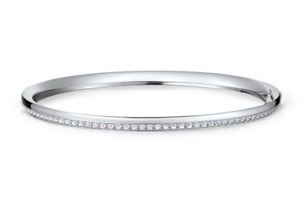 The Hearts on Fire Barre Pave Diamond Bangle features a sleek, silver design encrusted with small, sparkling diamonds along the outer edge. It has a smooth, polished finish and showcases a minimalist aesthetic.