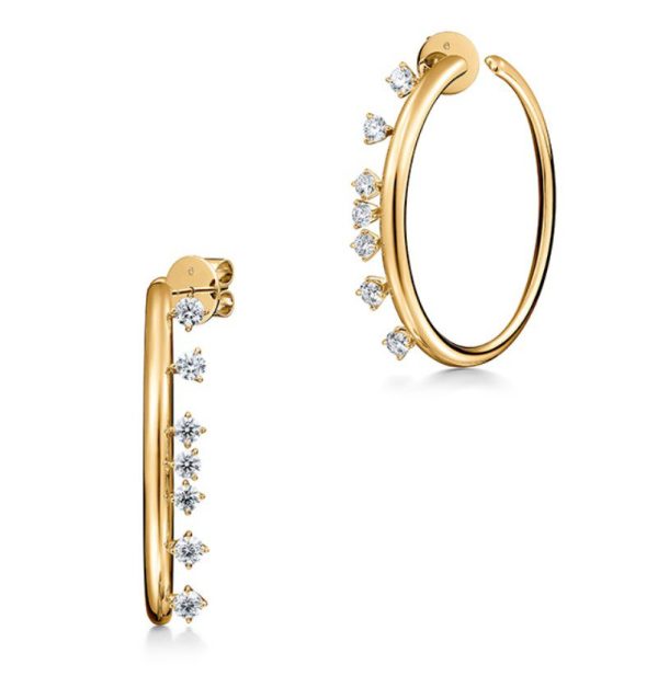 The Hearts on Fire Barre Floating Diamond Medium Hoops are a pair of gold hoop earrings featuring small, round, white gemstones evenly spaced along the outer edge. The earrings showcase a sleek design with a smooth gold finish, accented by shimmering diamonds.