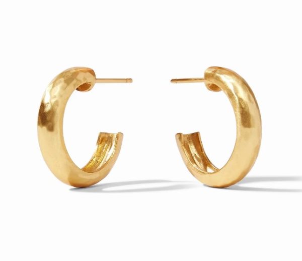 A pair of Julie Vos Havana Hoop Earrings in gold, featuring a polished and slightly textured surface, are placed upright on a white background. The thick hoops have a stud-style fastening, with shadows visible beneath them.