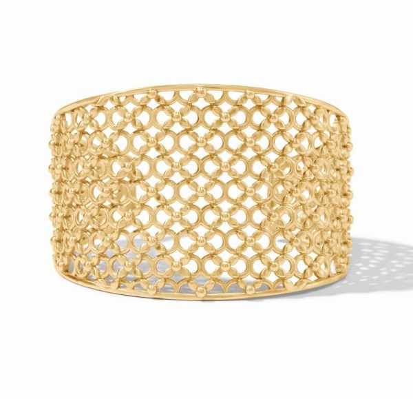 The Julie Vos Helene Cuff is a wide gold bracelet showcasing an intricate honeycomb lattice design, complete with interlocking loops and small spherical accents. The bracelet casts a subtle shadow on the surface below, emphasizing its detailed craftsmanship.