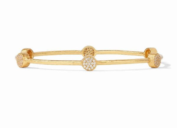 The Julie Vos Milano Luxe Pavé Bangle is a delicate gold bracelet featuring a double-band design with three circular clusters of small, sparkling white stones evenly spaced around the bangle. The overall design is elegant and refined, emphasizing the clusters as focal points.