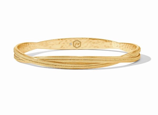 The Julie Vos Cheval Twist Bangle Bracelet features a textured design combining smooth, hammered, and intricately twisted elements. The inner side showcases a small hexagonal emblem inscribed with "IV" and adorned with a single tiny gem. This gold bangle casts a subtle shadow.