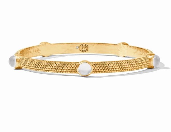 The Julie Vos Cabochon Bangle Bracelet in Iridescent Clear Crystal features a textured gold band adorned with three white round stones and a small hexagonal engraving on the inner side.