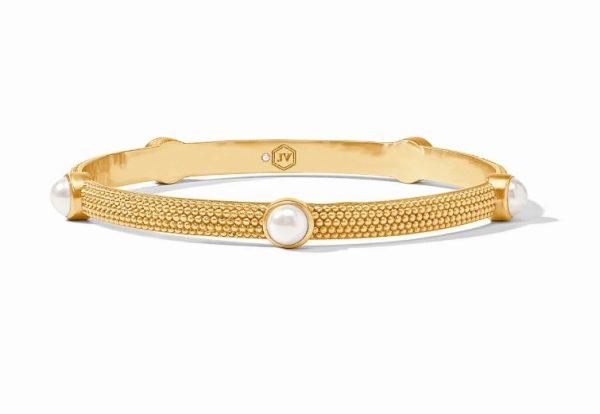 The Julie Vos Cabochon Bangle Bracelet - Pearl is a gold bracelet showcasing a textured design, elegantly adorned with round, white pearls that are evenly spaced along its circumference. The interior of the bracelet features a small, engraved logo.