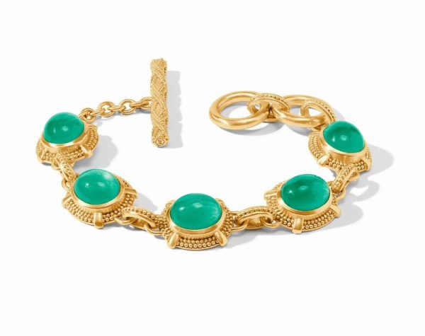 The Julie Vos Cabochon Bracelet - Iridescent Emerald Green showcases five evenly spaced oval green gemstones, each elegantly set in intricate gold bezels. The bracelet features a decorative toggle clasp and a short chain with an additional pair of gold rings against a plain white background.