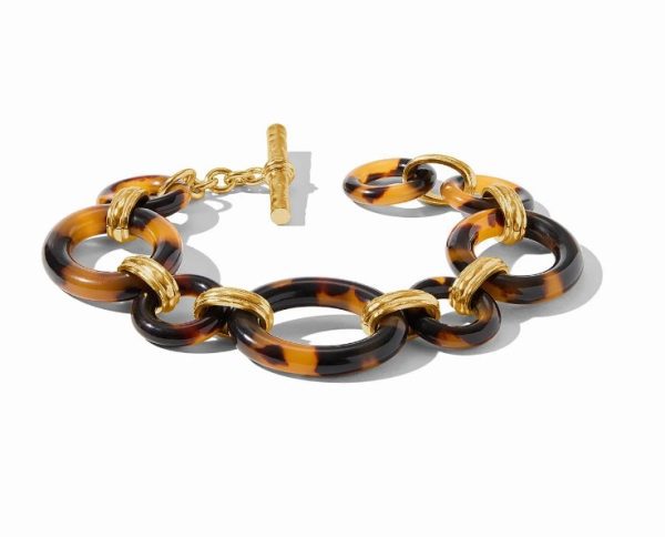 The Julie Vos Madison Link Bracelet is a stylish piece featuring large circular links adorned with a tortoiseshell pattern in shades of brown and black, interlinked with smaller, gold-toned rings. The bracelet includes a toggle clasp that combines elegance with a modern touch, all set against a plain white background.