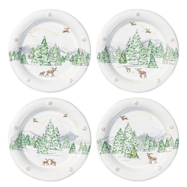 A set of four Juliska Berry & Thread North Pole Cocktail Plates, each illustrating a winter forest scene with evergreens, snow-clad ground, mountains, and deer. Santa and his sleigh fly through the sky on each plate. Though the designs differ slightly between plates, they uphold a consistent thematic unity.