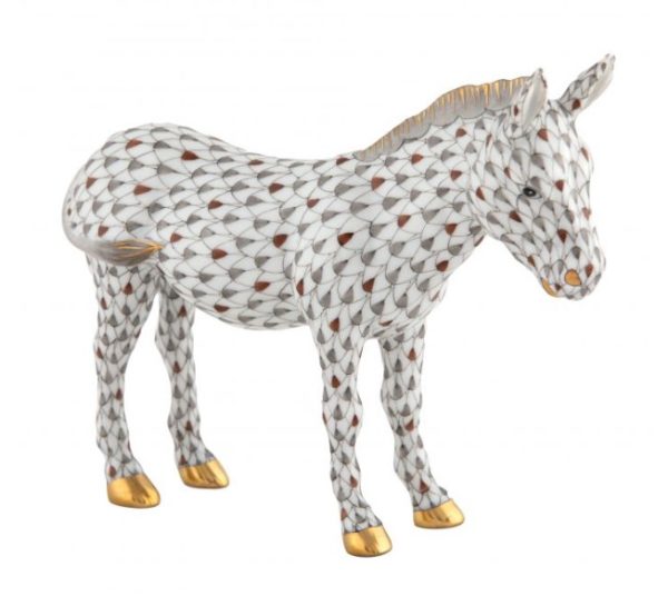 The Herend Nativity Donkey Figurine features a porcelain donkey with an intricate scale-like pattern in white and gray, accented with gold on its hooves, ears, and muzzle. The donkey is depicted standing with its head slightly lowered.