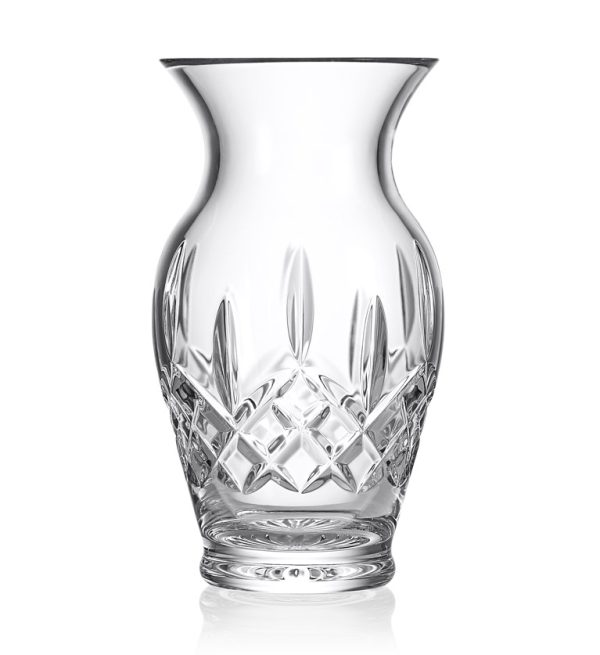 The Waterford Lismore 8" Vase features a clear, intricately cut crystal with an elegant, curvy silhouette and a wide, flared rim. The vase's surface is adorned with a detailed geometric pattern that catches and reflects light, enhancing its luxurious appearance.