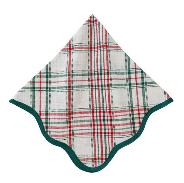 The Juliska Merry Tartan Napkin, featuring a white base adorned with a red and green plaid pattern and green trim, is folded with one corner pointing upward while the opposite side curves gracefully.