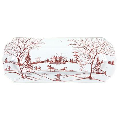 The Juliska Country Estate Winter Frolic 15" Hostess Tray is a rectangular platter with scalloped edges, featuring a picturesque winter scene in red and white. The scene depicts a countryside with bare trees, a distant house, horse-drawn sleighs, and people ice skating on a pond.