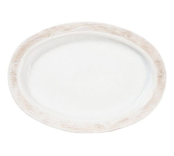 The Juliska Blenheim Oak 18" Platter showcases an oval shape with a textured, off-white rim adorned with a subtle, wavy pattern. Its central area is smooth and white, contributing to a clean and elegant design.