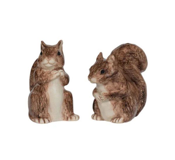 The Juliska Clever Creatures Squirrel Salt and Pepper Set consists of two ceramic figurines featuring squirrels sitting upright. Each squirrel boasts a light brown body with white accents on the chest and face, displaying intricate fur textures while holding their front paws to their chests. The background is a simple, plain white.