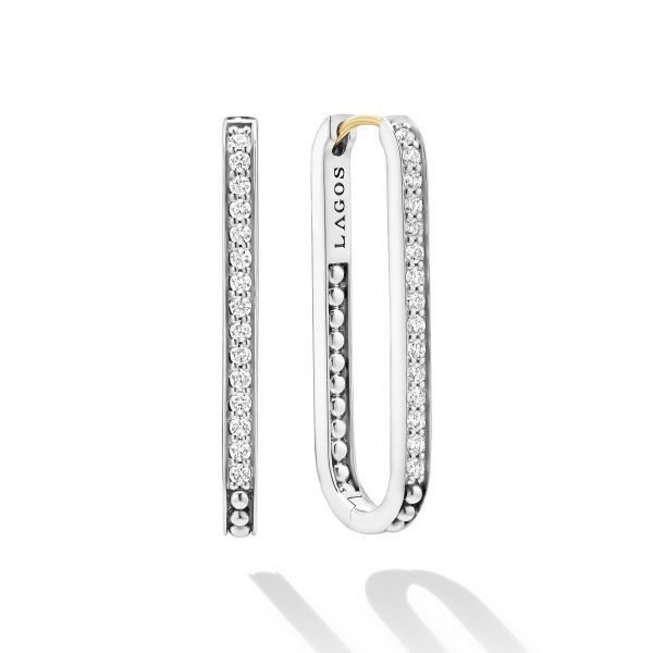 The LAGOS Caviar Spark Large Linear Diamond Hoop Earrings showcase a sleek and modern design, with small diamonds encrusted on the rectangular hoops. One earring faces forward, displaying the "LAGOS" brand name, while the other is shown in profile. The earrings have a silver finish with a subtle shadow.