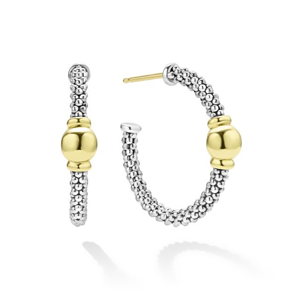 The LAGOS Signature Caviar Two-Tone Station Hoop Earrings showcase a design featuring small silver beads and a smooth, round gold bead accent at the center. One earring is displayed from the front, while the other is shown in a side view, highlighting their classic yet modern aesthetic.