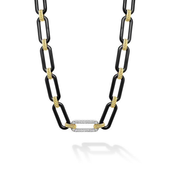 The LAGOS Signature Caviar 18K Gold and Black Ceramic Diamond Station Link Necklace showcases an alternating pattern of black and gold rectangular links, with a central oval link encrusted with small diamonds. The design blends bold and delicate elements to create a striking contrast.