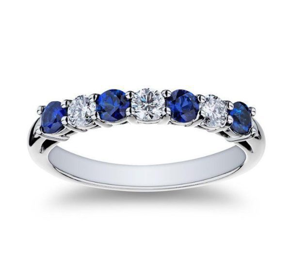 Introducing the Bromberg's Signature Collection Sapphire and Diamond Band – a silver ring adorned with alternating round blue sapphires and white diamonds, meticulously set in a single row across the top. This elegant band boasts five stunning blue sapphires and four brilliant white diamonds, crafting a balanced and sophisticated design against a plain white background.