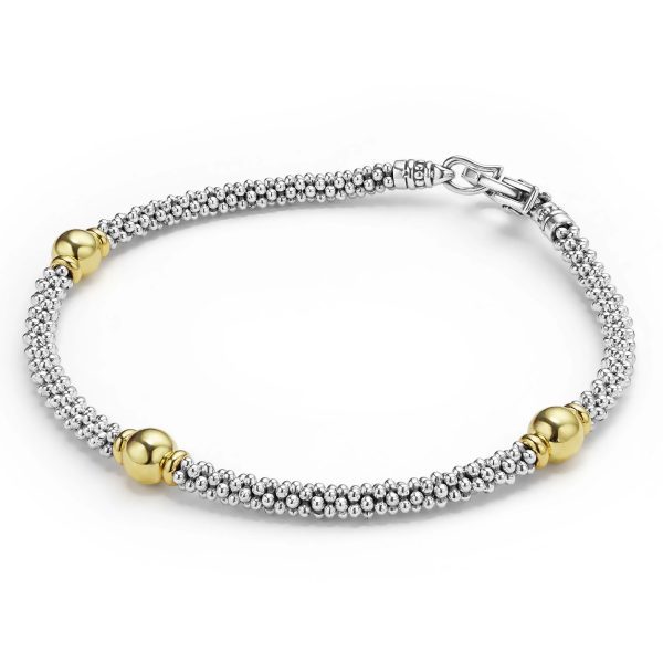 The Signature Caviar Two-Tone Station Bracelet is a stylish silver beaded accessory adorned with three evenly spaced gold spheres. It features a secure clasp, making it both elegant and practical for various occasions. The contrasting gold and silver elements create a sophisticated and modern look.